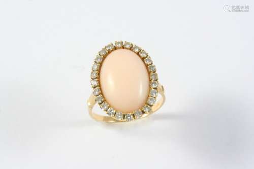A CORAL AND DIAMOND CLUSTER RING the oval-shaped coral is se...