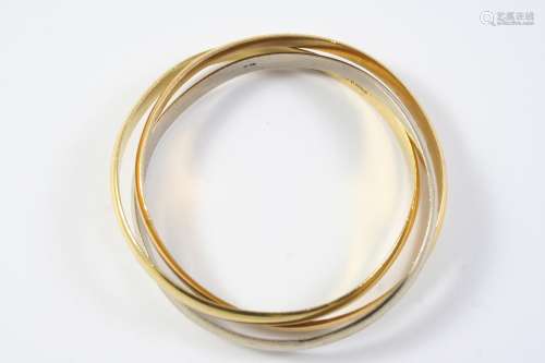 AN 18CT TWO COLOUR GOLD TRIPLE BAND BANGLE formed with three...