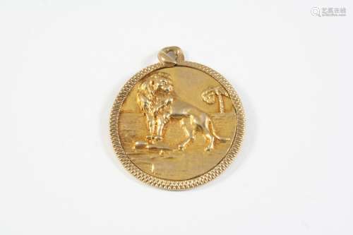 A 9CT GOLD CIRCULAR PENDANT with embossed decoration depicti...