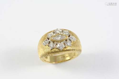 A DIAMOND AND GOLD RING the 18ct gold textured band is set w...