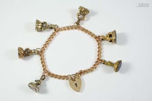 A 9CT GOLD CURB LINK BRACELET with padlock clasp and suspend...