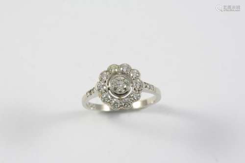 A DIAMOND CLUSTER RING the flowerhead design is set with cir...