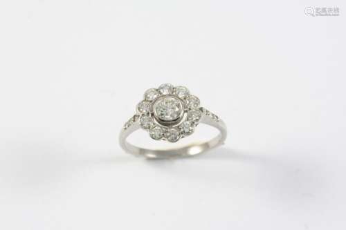 A DIAMOND CLUSTER RING of flowerhead form, set with circular...