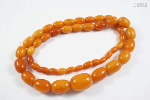 A GRADUATED AMBER BEAD NECKLACE 68cm long, 60 grams