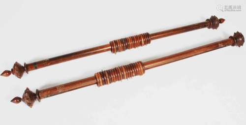 A pair of 19th century mahogany curtain poles and rings, the...