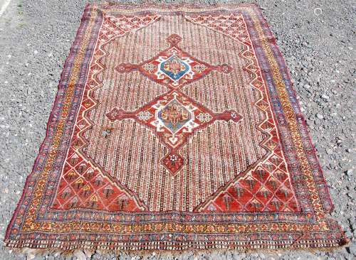 A Persian rug, early 20th century, the striped ground centre...