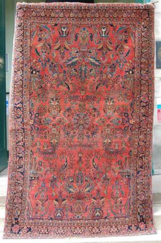 A Persian rug, early 20th century, the madder ground centred...