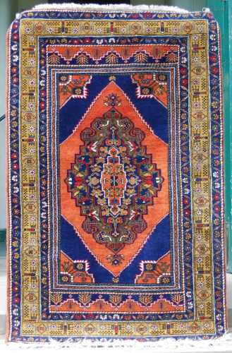 A Persian rug, 20th century, the madder and blue rectangular...
