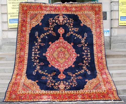 A Persian rug, 20th century, the cobalt blue rectangular fie...
