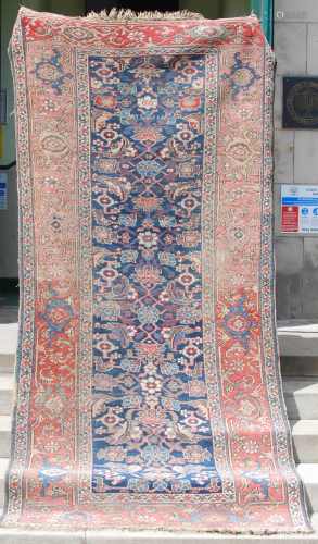 A Persian long rug, late 19th century, the rectangular blue ...