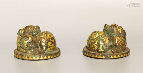A pair of bronze paper weight ware with gold and silver