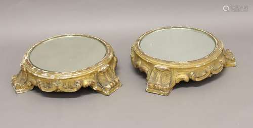 A PAIR OF ROCOCO STYLE DISPLAY STANDS. Each carved and gilt,...