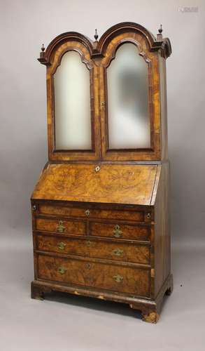 A GEORGE I WALNUT DOUBLE DOME TOPPED BUREAU BOOKCASE. The do...