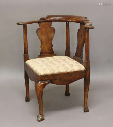 A GEORGE III PROVINCIAL CORNER CHAIR, with scrolling top rai...