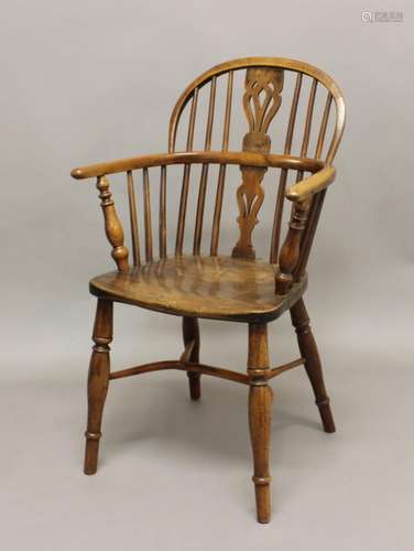 A YEW AND ELM WINDSOR ARMCHAIR, 19th century, the arched bac...