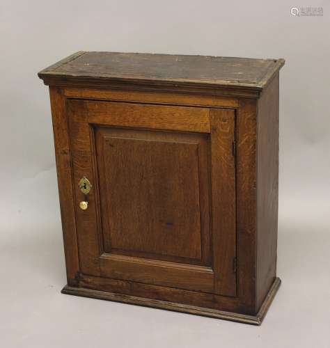 AN 18TH CENTURY OAK CUPBOARD, with panelled door, the interi...