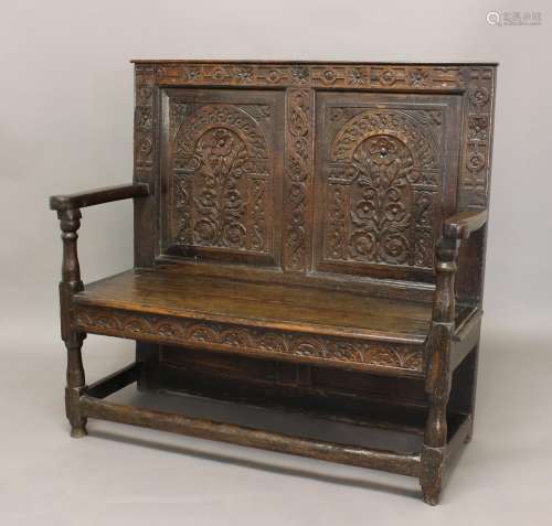 AN OAK SETTLE, late 17th century, the two-panelled back carv...