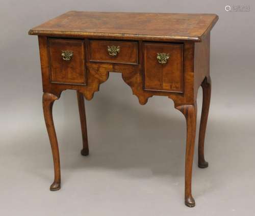 A GEORGE I WALNUT LOWBOY. A George I walnut veneered lowboy,...