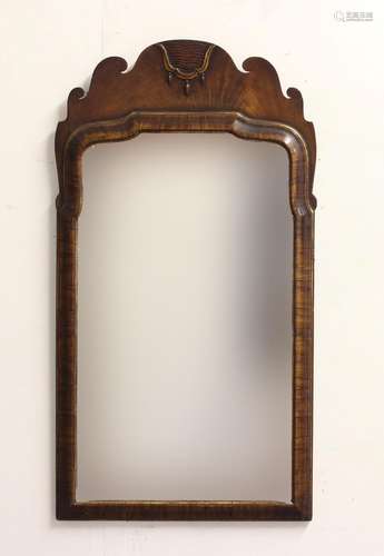 A GEORGE II STYLE WALL MIRROR. An arch topped mirror with be...