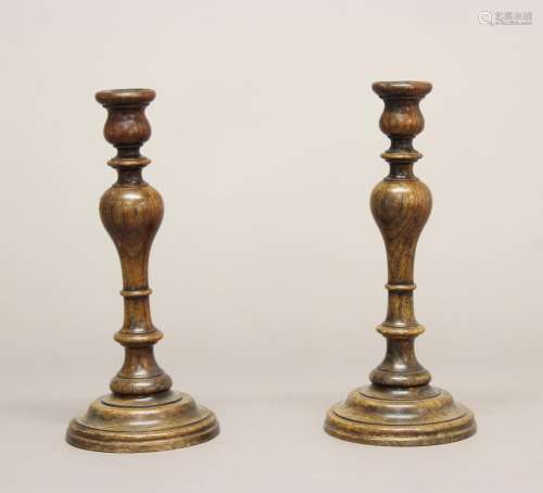A PAIR OF VICTORIAN TURNED OAK CANDLESTICKS. A pair of tall ...