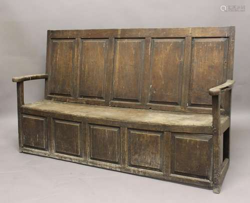 AN 18TH CENTURY OAK SETTLE, with panelled back and slightly ...