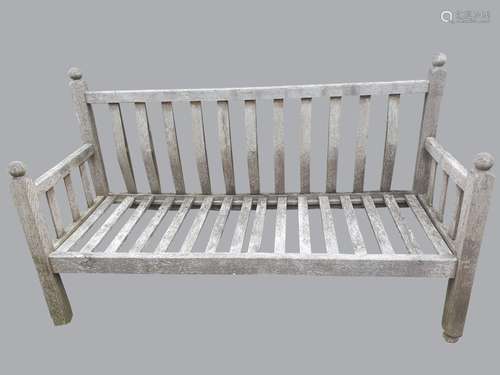 A LARGE TEAK GARDEN BENCH. A large teak garden bench, the ra...