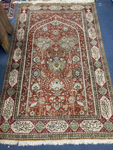 A Qum silk prayer rug,the red field with mihrab, palmettes, ...