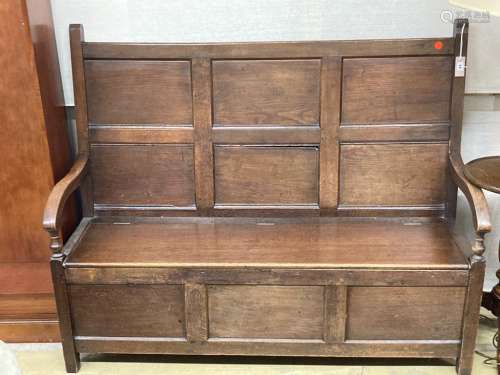 A mid 18th century panelled oak hinged box seat settle, leng...