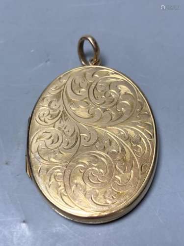 A 1960's engraved 9ct gold mounted oval pendant locket,41mm,...