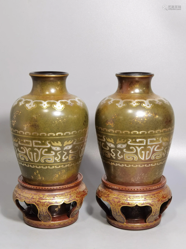 A pair of gilt and silver vases with fine tea leaves,