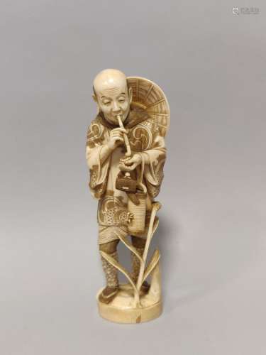 JAPON. OKIMONO en ivoire sculpté représentant un homme debou...