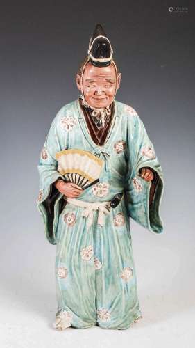 A Japanese pottery figure of a street entertainer, late 19th...