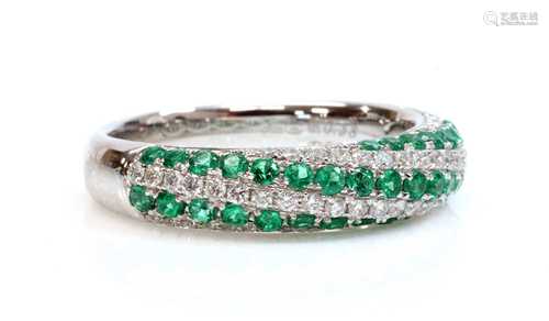 An 18ct white gold emerald and diamond half hoop ring,