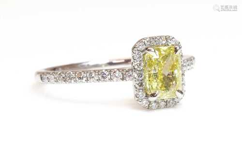 A platinum fancy yellow diamond and diamond halo cluster rin...