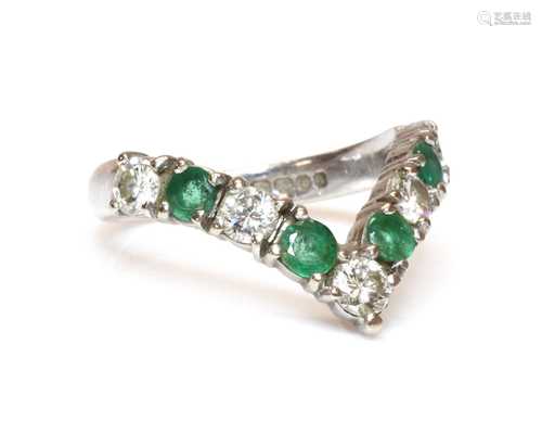 An 18ct white gold diamond and emerald half wishbone ring,