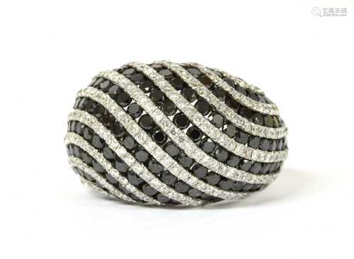 A white gold, black and white diamond bombé ring,