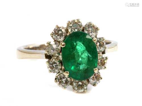 An 18ct white gold emerald and diamond oval cluster ring,