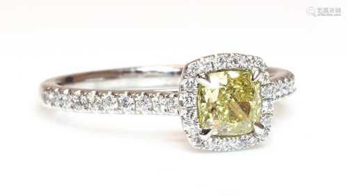 A platinum fancy yellow diamond and diamond halo cluster rin...