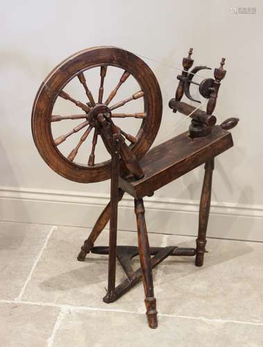 An early 20th century oak spinning wheel, extensively carved...