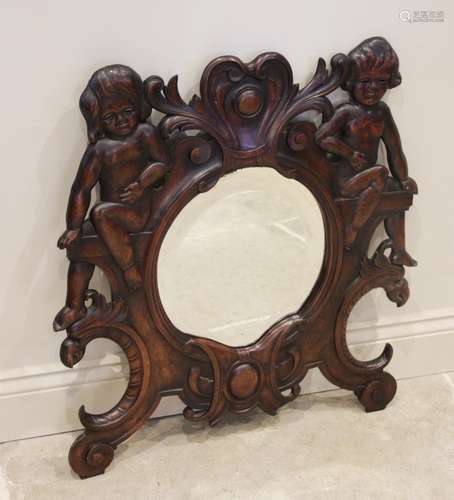 A late 19th century Italian walnut wall mirror, the oval bev...