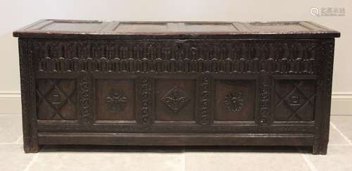 A 17th century oak coffer, the hinged cover with four invert...