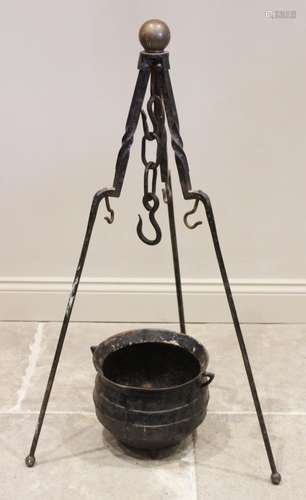 A 19th century iron cauldron and tripod stand, the tripod wi...