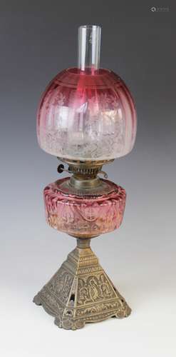 A Victorian brass and cranberry glass oil lamp, 19th century...