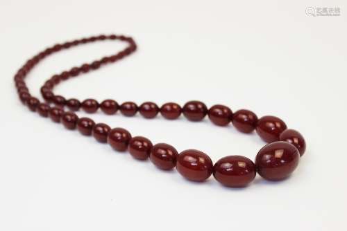 A cherry amber bead necklace, comprising fifty-seven polishe...