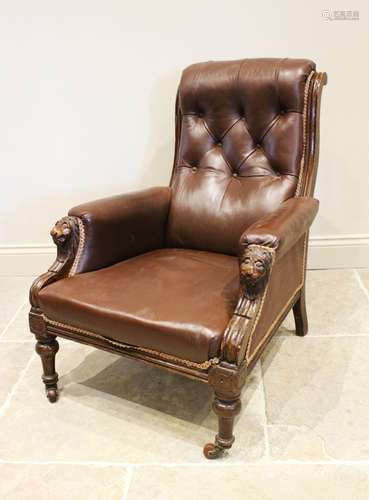 A Victorian walnut and leather library armchair, the curved ...