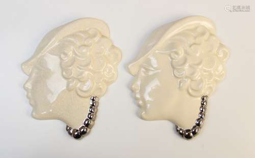 A pair of Art Deco silver lustre porcelain wall masks, each ...