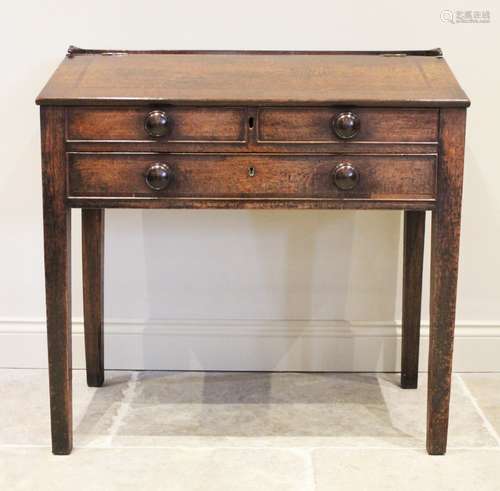 A George III oak clerks desk, the three quarter galleried to...