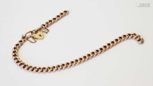 A yellow metal curb link bracelet, 21.5cm long, suspending a...