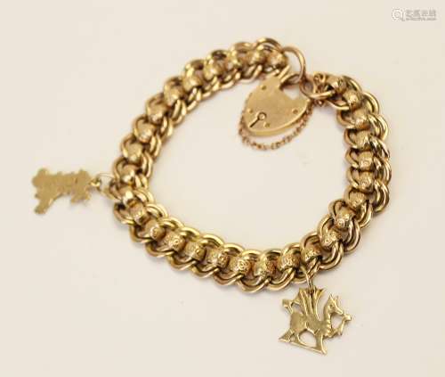 An early 20th century yellow metal charm bracelet, double cu...