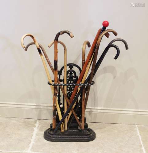 A Victorian style cast iron stick stand, the open work uprig...